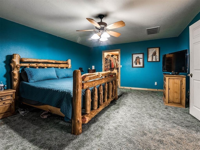 carpeted bedroom with a spacious closet, ceiling fan, a closet, and a textured ceiling