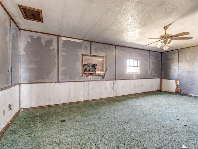 basement with a textured ceiling, carpet floors, and ceiling fan