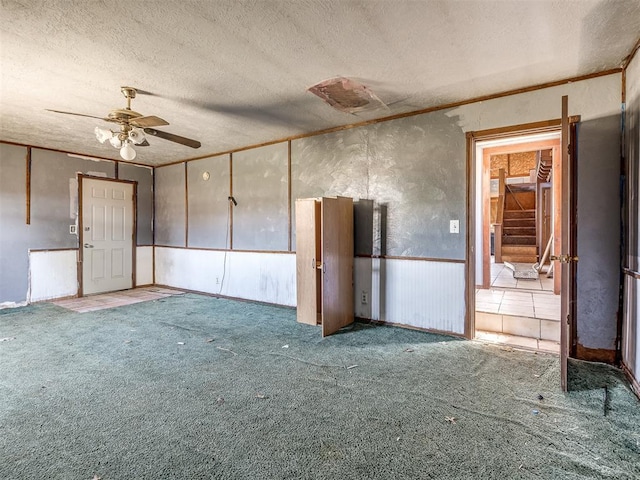 interior space featuring carpet, ceiling fan, and a textured ceiling