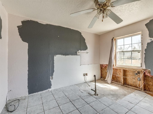 spare room with ceiling fan and a textured ceiling