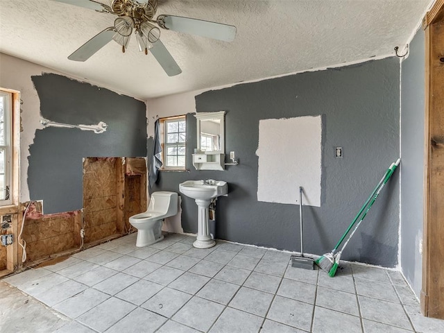 bathroom featuring tile patterned flooring, a textured ceiling, toilet, and ceiling fan