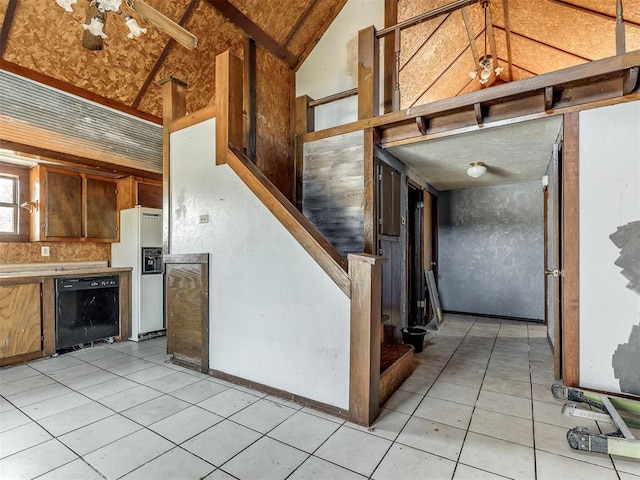 kitchen with light tile patterned floors, black dishwasher, high vaulted ceiling, and white fridge with ice dispenser