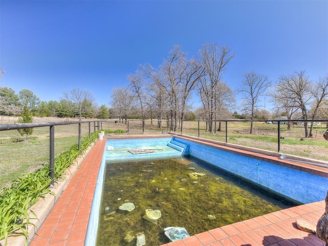 view of swimming pool featuring a rural view