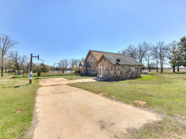 view of side of home with a yard and a rural view