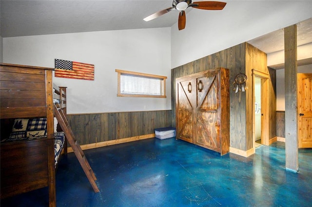 44 Blue Ivey Cir, Broken Bow, OK 74728 - unfurnished bedroom featuring wooden walls, concrete floors, high vaulted ceiling, and a wainscoted wall