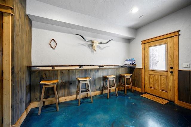 44 Blue Ivey Cir, Broken Bow, OK 74728 - indoor dry bar with wood walls, wainscoting, concrete floors, and a textured ceiling