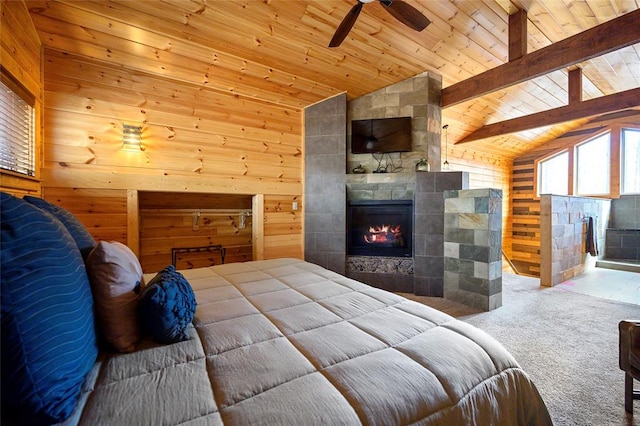 carpeted bedroom featuring ceiling fan, lofted ceiling with beams, wood walls, a fireplace, and wood ceiling