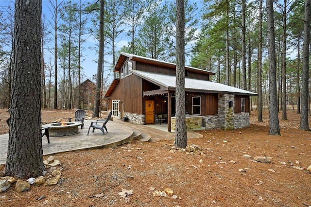 view of side of property with a patio and an outdoor fire pit