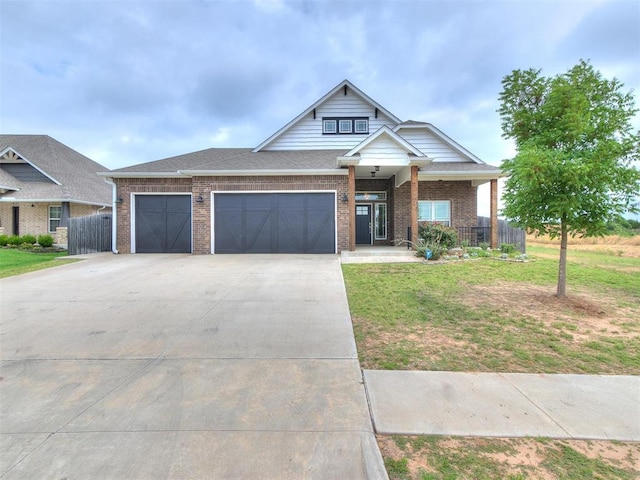 craftsman house with a garage and a front lawn