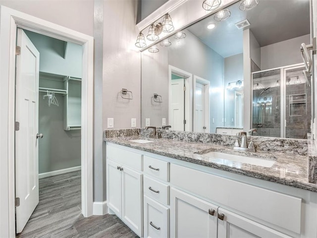 bathroom featuring hardwood / wood-style floors, vanity, and walk in shower