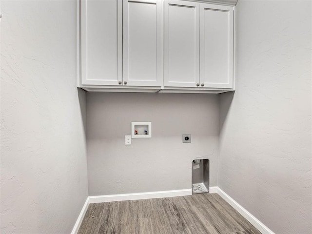 clothes washing area with electric dryer hookup, hookup for a washing machine, cabinets, and hardwood / wood-style flooring