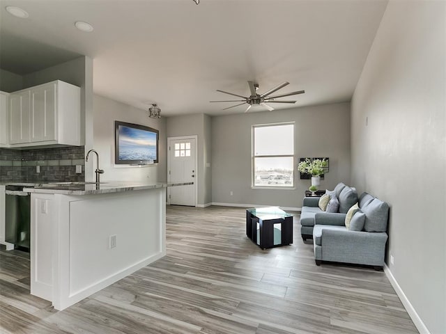 living room featuring ceiling fan, sink, and light hardwood / wood-style floors