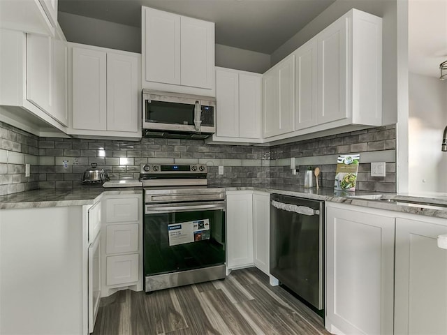 kitchen with sink, dark hardwood / wood-style flooring, white cabinets, stainless steel appliances, and backsplash