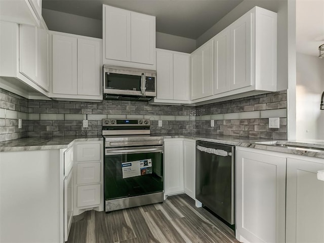 kitchen with sink, appliances with stainless steel finishes, dark hardwood / wood-style flooring, white cabinets, and backsplash