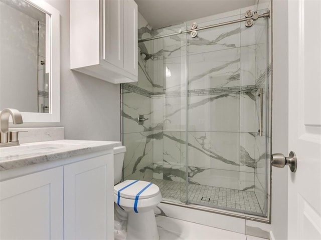 bathroom with vanity, toilet, and a shower with shower door