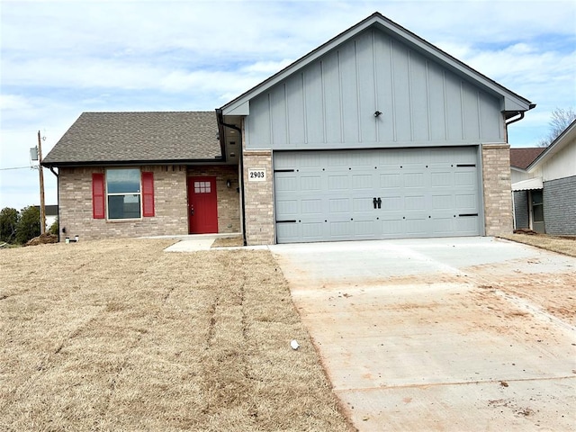 view of front of house with a garage, brick siding, driveway, roof with shingles, and board and batten siding