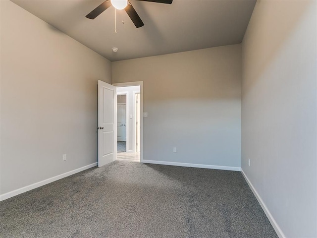 carpeted empty room with ceiling fan and baseboards