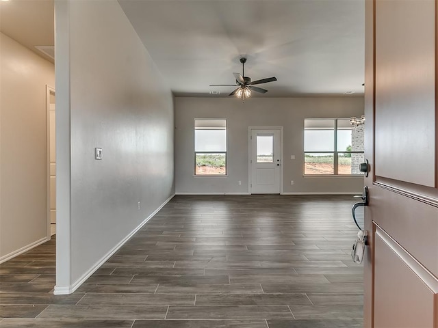 interior space with ceiling fan with notable chandelier and dark hardwood / wood-style floors