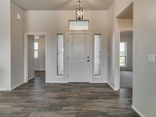 foyer featuring dark hardwood / wood-style flooring and an inviting chandelier