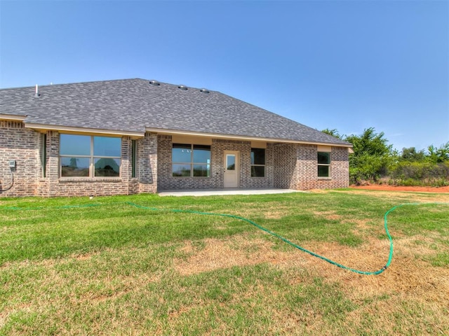 rear view of house with a patio area and a lawn