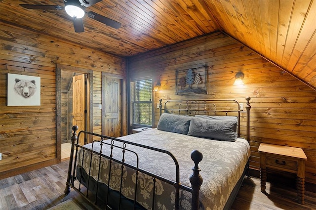 bedroom with hardwood / wood-style flooring, vaulted ceiling, ceiling fan, and wooden walls