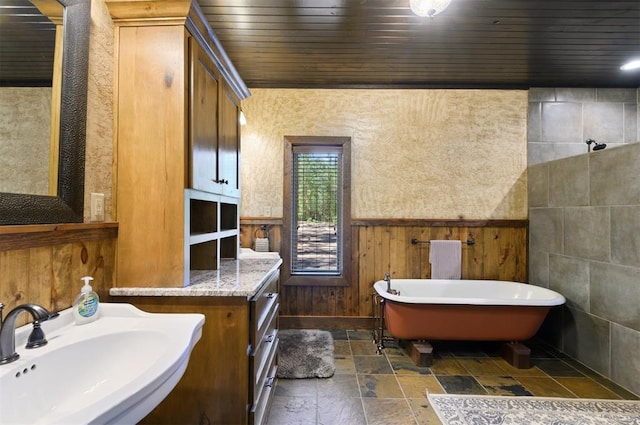 bathroom featuring a bathtub, wood walls, wood ceiling, and sink