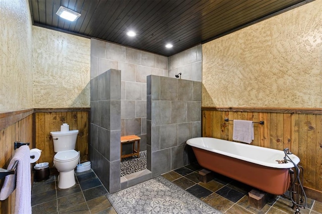 bathroom with wood walls, toilet, shower with separate bathtub, and tile walls