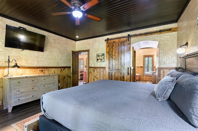 bedroom with wood walls, a barn door, wood-type flooring, and wood ceiling