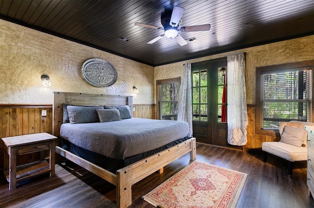 bedroom with dark hardwood / wood-style flooring, wooden ceiling, and wood walls