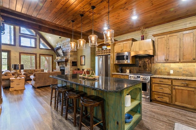 kitchen featuring stainless steel appliances, dark hardwood / wood-style flooring, decorative light fixtures, a kitchen island, and custom exhaust hood