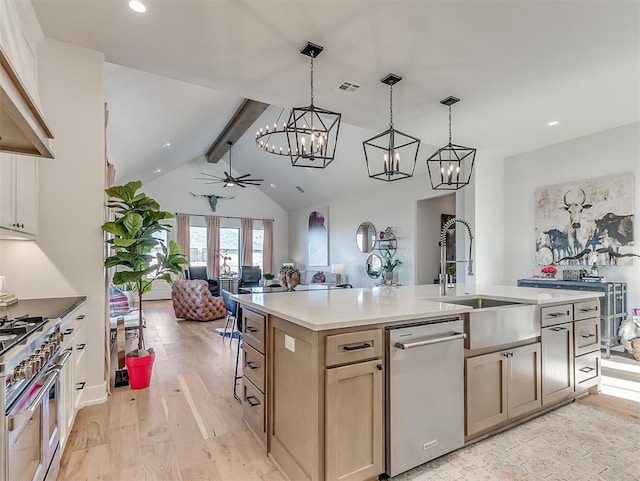 kitchen with ceiling fan, stainless steel appliances, light hardwood / wood-style flooring, lofted ceiling with beams, and a kitchen island with sink