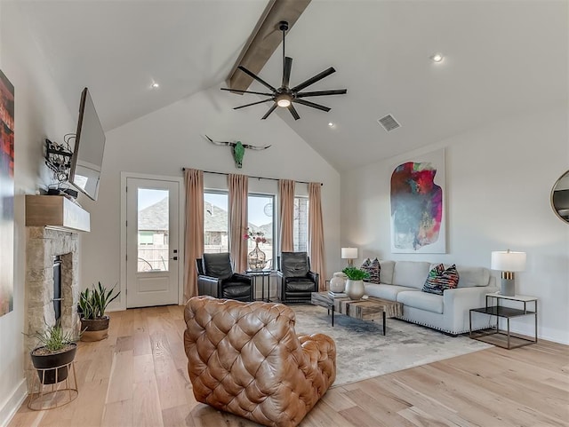 living room featuring ceiling fan, light hardwood / wood-style flooring, beamed ceiling, and high vaulted ceiling