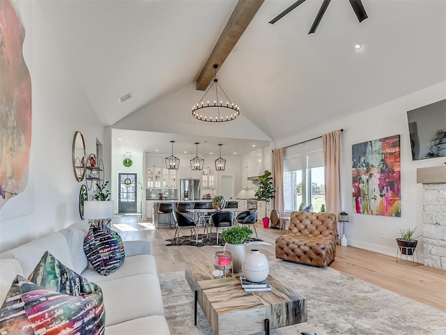 living room featuring beam ceiling, ceiling fan with notable chandelier, light hardwood / wood-style floors, and high vaulted ceiling