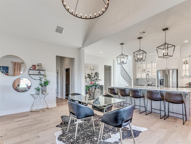 dining room with light hardwood / wood-style flooring, lofted ceiling, and sink