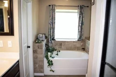 bathroom featuring a bathing tub, a wealth of natural light, and vanity