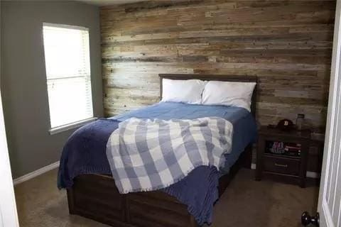 bedroom featuring wooden walls and multiple windows