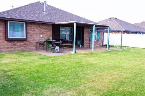 rear view of property with a lawn and a patio