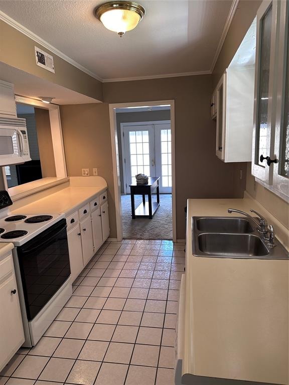 kitchen with white appliances, white cabinetry, sink, and light tile patterned floors