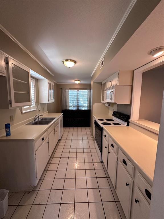 kitchen with white appliances, crown molding, sink, light tile patterned floors, and white cabinetry