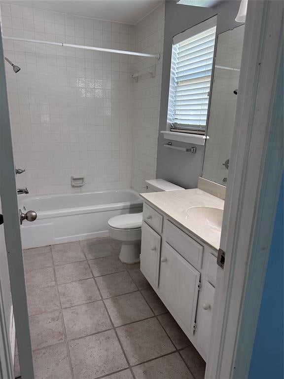 full bathroom featuring tiled shower / bath, tile patterned flooring, vanity, and toilet