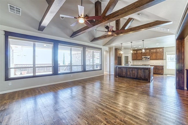 unfurnished living room featuring baseboards, ceiling fan, beam ceiling, and visible vents