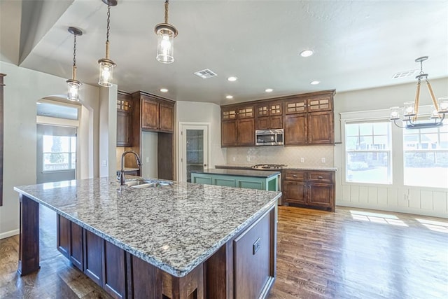 kitchen with a notable chandelier, appliances with stainless steel finishes, a sink, visible vents, and a spacious island