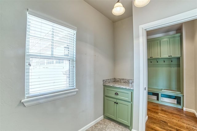 interior space featuring baseboards and light wood finished floors