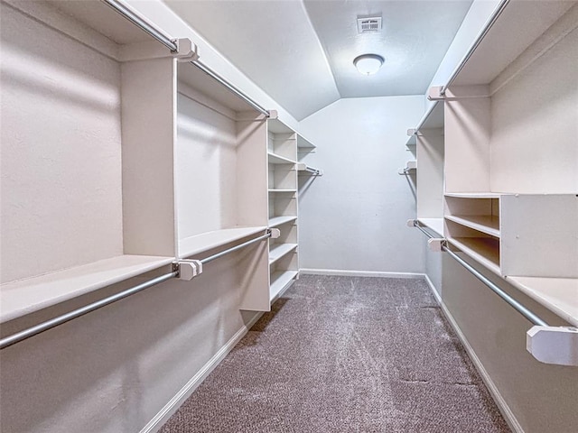 spacious closet featuring carpet floors, visible vents, and vaulted ceiling