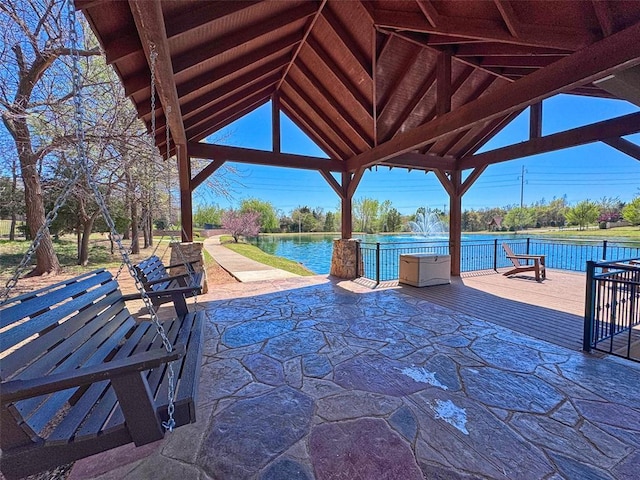 view of patio featuring a gazebo and a deck with water view