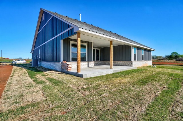 rear view of property with a yard and a patio