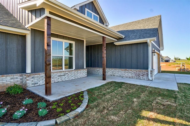 view of exterior entry featuring a garage and a yard