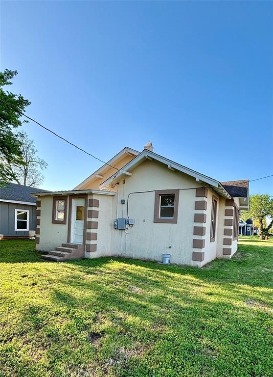 back of property featuring a yard