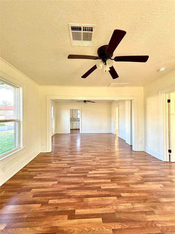 unfurnished room featuring a textured ceiling, light hardwood / wood-style floors, and ceiling fan