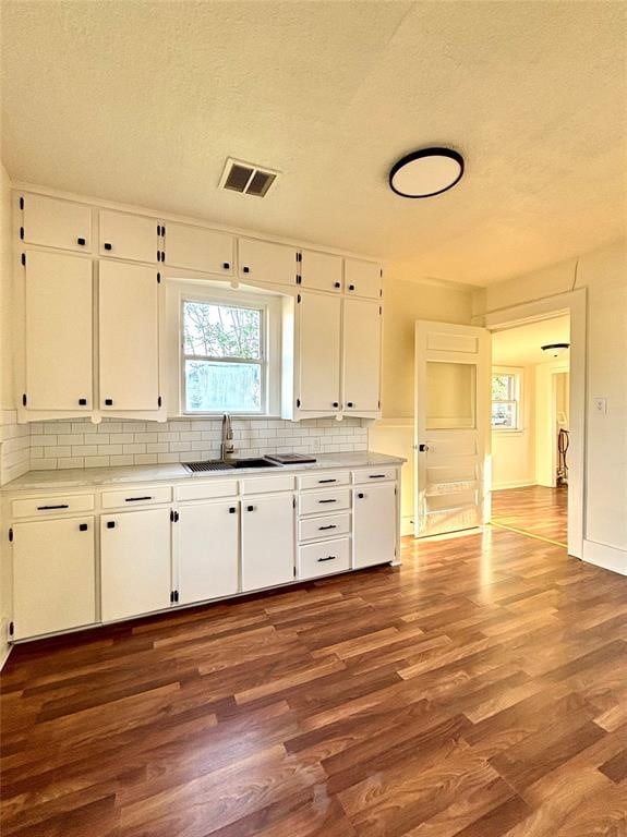 kitchen with backsplash, white cabinetry, a textured ceiling, and dark hardwood / wood-style floors